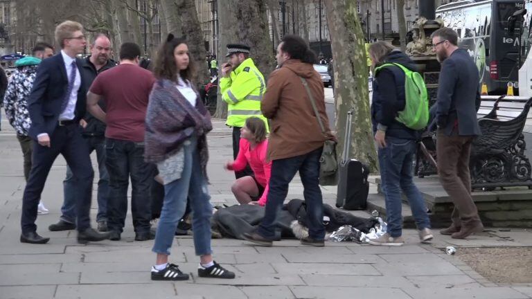 In this image from video, a girl lying on the ground is treated by passers-by on the Embankment near to the Houses of Parliament in London, Wednesday March 22, 2017.  Britain has been targeted Wednesday by what authorities are calling a terrorist incident