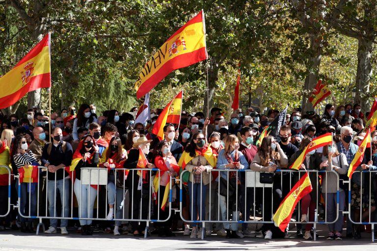 Banderas de España ondean entre los asistentes al acto organizado con motivo del Día de la Fiesta Nacional, en Madrid este lunes. (Foto: EFE/Kiko Huesca/POOL)