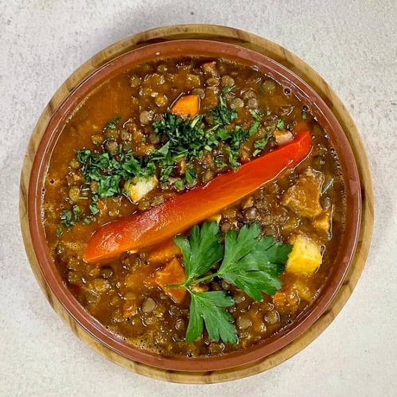 Un plato de guiso de lentejas del restaurante La Gran Familia.