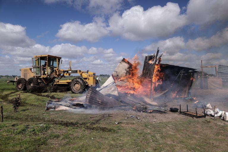 Vehículos especiales destruyen las viviendas improvisadas en un predio ocupado de manera ilegal en Guernica (EFE/ Juan Ignacio Roncoroni)