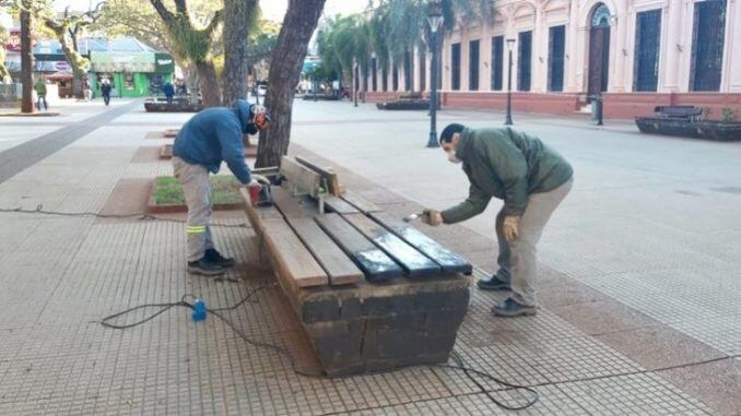 Pintura de asientos de madera y piedra en la Plaza 9 de Julio de Posadas.