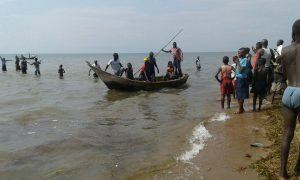 Rescuers are seen on a fishing boat on Lake Albert, on December 26, 2016 in Buliisa, after at least 30 Ugandan members of a village football team and their fans drowned when their boat capsized on Lake Albert during a party.
Police officers working with l