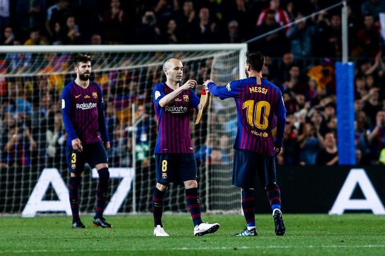 Andrés Iniesta se saluda con Lionel Messi.