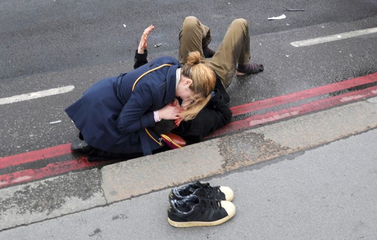 A woman assist an injured person after an incident on Westminster Bridge in London, March 22, 2017.   REUTERS/Toby Melville TPX IMAGES OF THE DAY