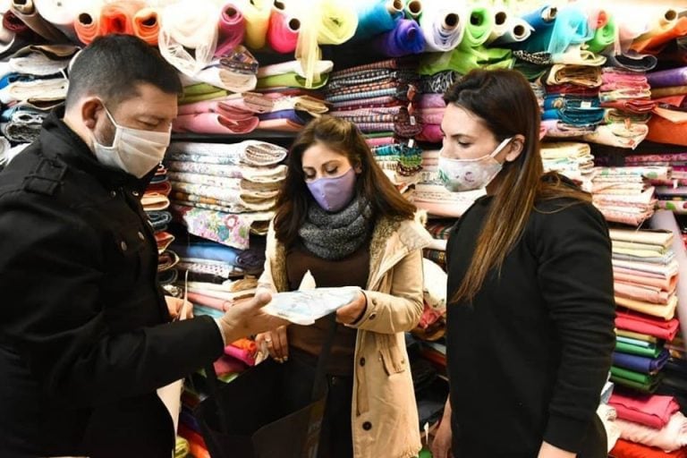 David Ferreyra entregando kits sanitizantes en comercios.