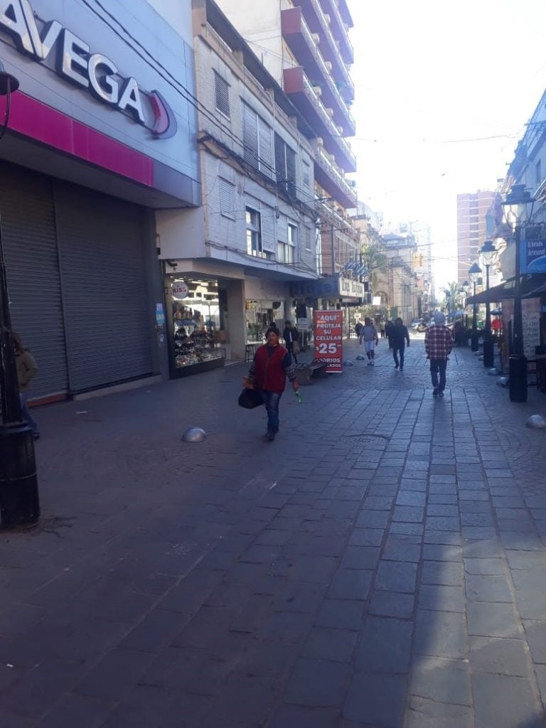 Peatonal Belgrano muestra una imagen diferente con las persianas bajas de los comercios y pocos transeúntes.