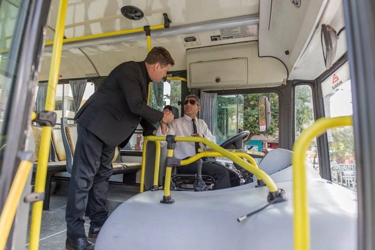 Briner junto al chófer de colectivo.