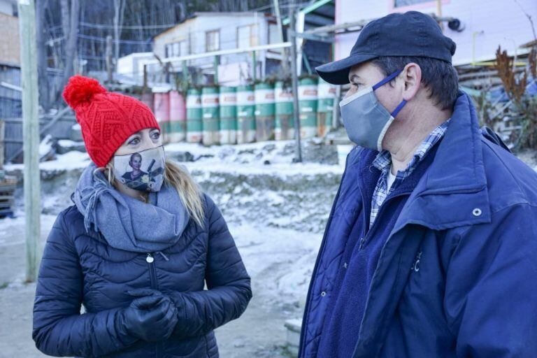 Lorena Henriques Sanches junto a funcionarios del Municipio acercando agua y leña