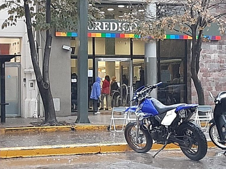 El público se agolpó en los halls de entrada de los bancos, evitando la lluvia en la reapertura de los bancos.