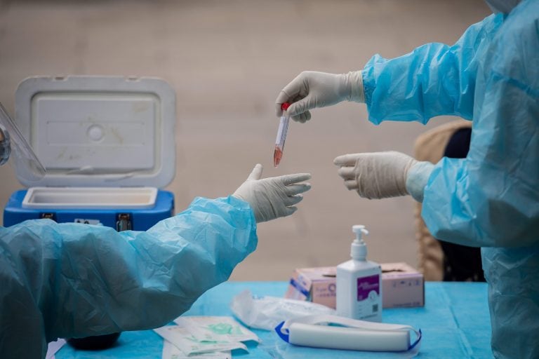 Medical workers wearing full protective gear prepare to take swab samples from a journalist (not pictured) to test for the COVID-19 coronavirus, nine hours before the closing ceremony of the National People's Congress (NPC) at the Diaoyutai hotel in Beijing on May 28, 2020. - All journalists accredited to cover the National People's Congress events have to pass the COVID-19 test. (Photo by NICOLAS ASFOURI / AFP)