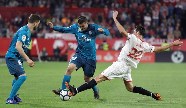 GRAF3184. SEVILLA. 09/05/2018. El centrocampista croata del Real Madrid, Mateo Kovacic (c), intenta llevarse el balón ante el jugador argentino del Sevilla, Franco "el mudo" Vázquez, durante el encuentro correspondiente a la jornada 34 de primera división disputado esta noche en el estadio Sánchez Pizjuán, en Sevilla. EFE/Julio Muñoz. españa sevilla  futbol liga primera division de españa futbolistas partido sevilla vs real madrid