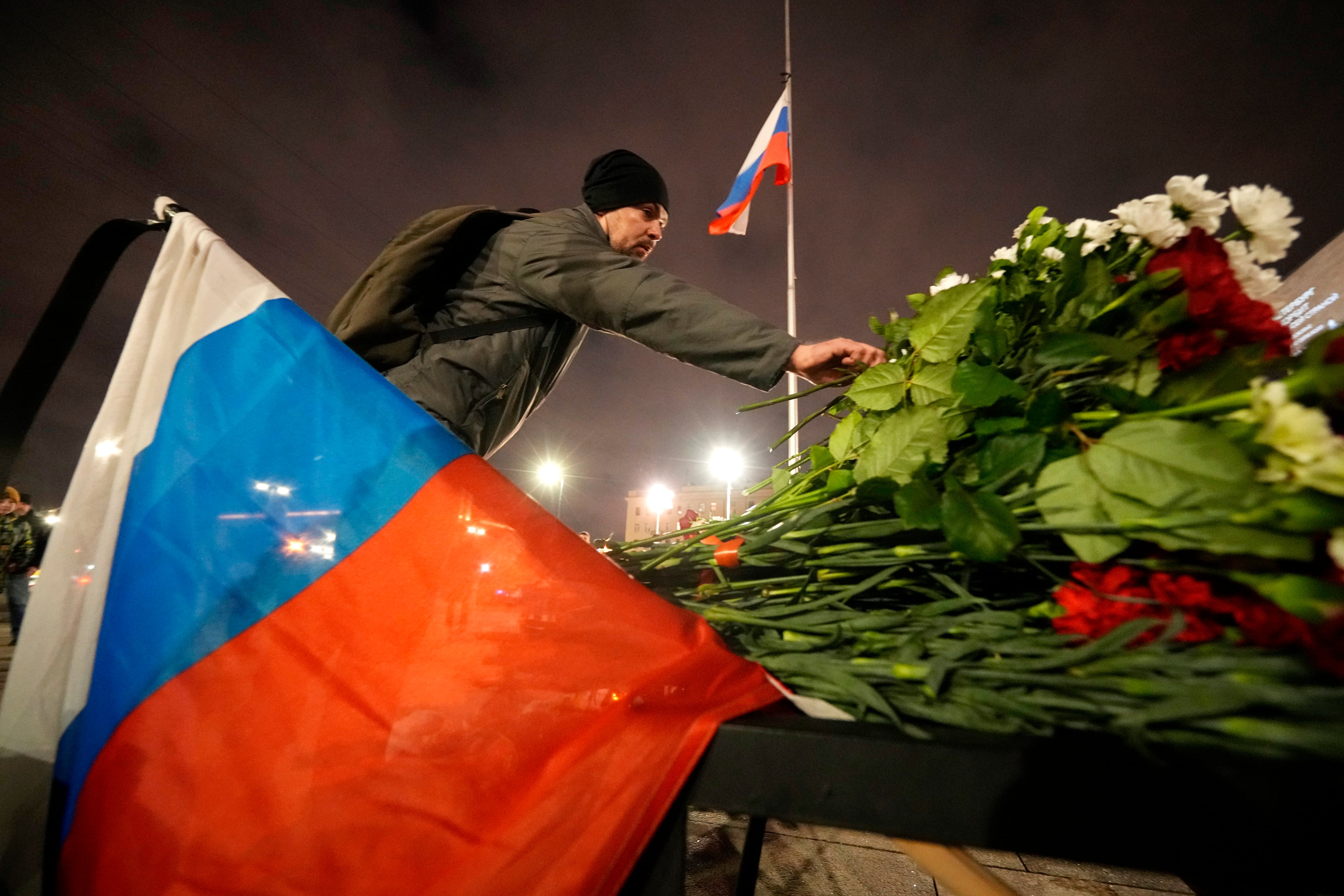 Un hombre coloca flores en un altar improvisado a las víctimas del ataque en Moscú, en San Petersburgo, Rusia, el sábado 23 de marzo de 2024.