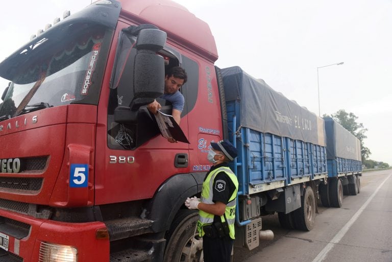 A police officer asks a truck driver for a special permission to drive, as towns that are near the Rosario grains export hub have been blocked for ground transportation as Argentina locks down against the coronavirus (COVID-19) disease, in Roldan, Santa Fe, Argentina April 1, 2020. REUTERS/Stringe