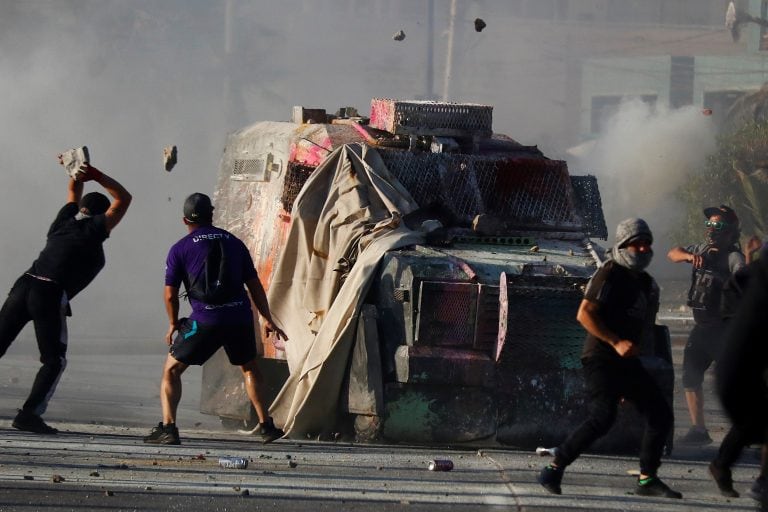 Chile, Viña del Mar: los manifestantes arrojan piedras a un vehículo policial blindado durante los enfrentamientos con la policía. Durante semanas, Chile ha experimentado fuertes protestas contra el alto costo de la vida y la desigualdad social. Crédito: Leonardo Rubilar / Agencia Uno / dpa.