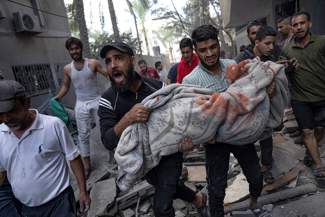 Palestinos evacuan a los heridos de un edificio destruido durante el bombardeo israelí en el campo de refugiados de Rafah, en la Franja de Gaza.