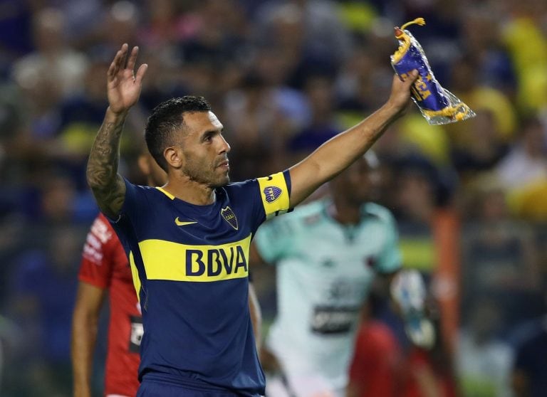 Boca Juniors' Carlos Tevez (R) holds up the team standard after their Argentina First Division Superliga football match against Colon at La Bombonera stadium, in Buenos Aires, on September 27, 2018.
Carlos Tevez returned to Boca Juniors after cutting short a spell with Chinese Super League side Shanghai Shenhua. / AFP PHOTO / ALEJANDRO PAGNI cancha de boca juniors carlos tevez campeonato torneo superliga de primera division futbol futbolistas partido boca juniors union de santa fe