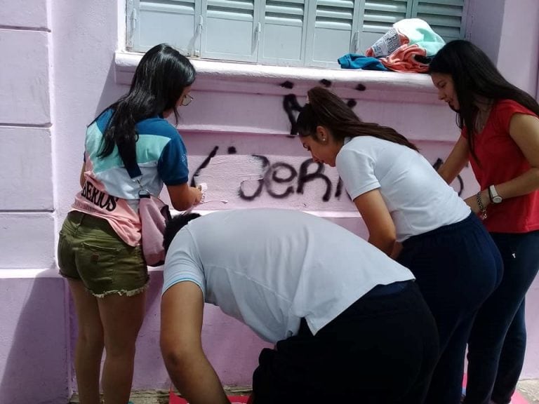 Liberios y sus padres arreglando las pintadas en la escuela Paula Dominguez de Bazán.