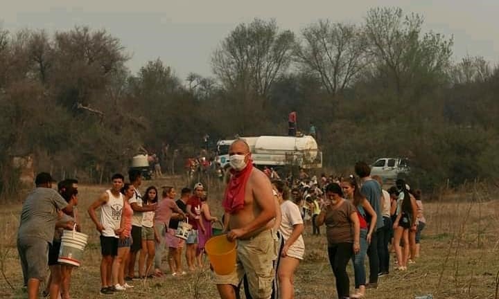 En Mina Clavero se formó un corredor humano de acarreo de agua para combatir los incendios. (Belen Intima)