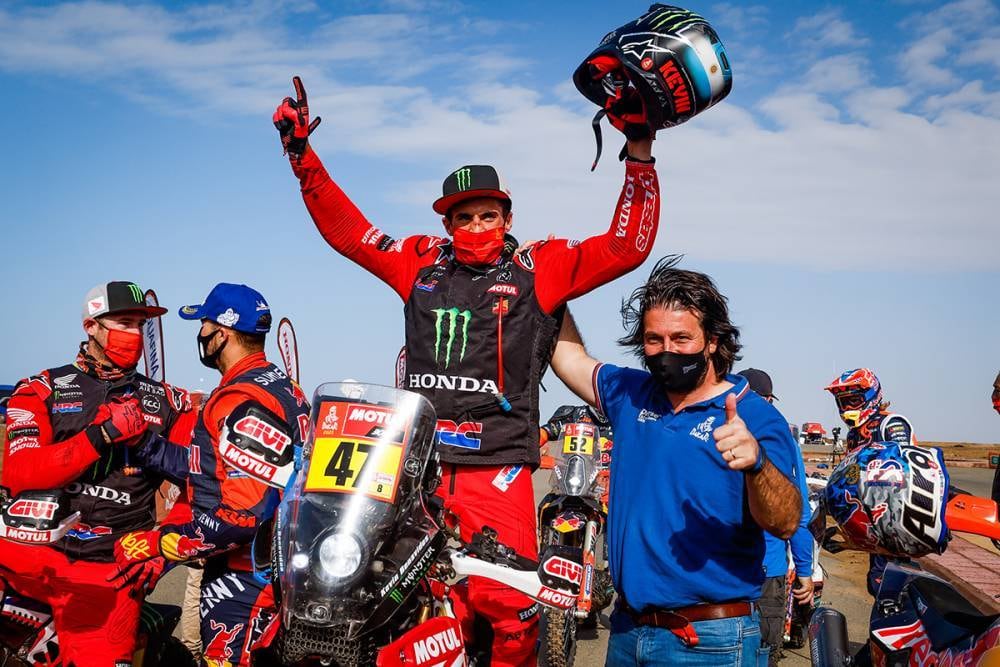 El salteño Kevin Benavides, victorioso con Honda en la llegada del Dakar 2021. Lo recibe David Castera, director del Dakar.