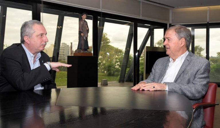 Hugo Passalacqua y el gobernador de Córdoba Juan Schiaretti reunidos este mes en Córdoba. Al fondo, en el despacho del gobernador una imagen del santo Cura Brochero. (Prensa)