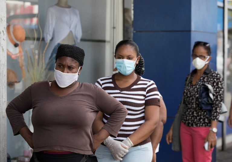 STO01. SANTO DOMINGO (REPÚBLICA DOMINICANA), 21/05/2020.- Un grupo de personas hacen fila para ingresar a una tienda cuando comerciantes comienzan a abrir sus negocios tras dos meses de suspensión en Santo Domingo (República Dominicana). El país inició ayer la fase 1 de la desescalada de las restricciones impuestas por el coronavirus, con la reapertura de comercios, industrias y transporte público. EFE/ Orlando Barría