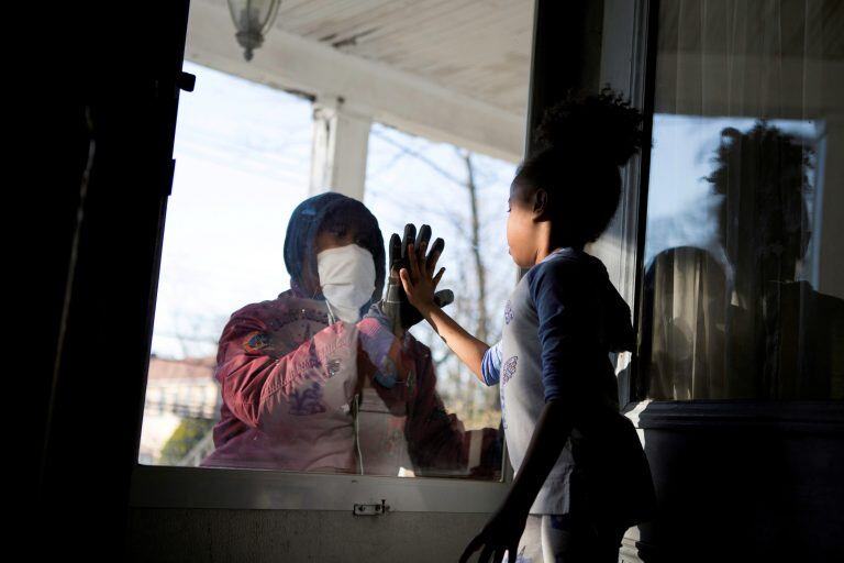 Una trabajadora saluda a sus hijos a través del vidrio en Nueva York (Foto: Joy Malone/REUTERS)