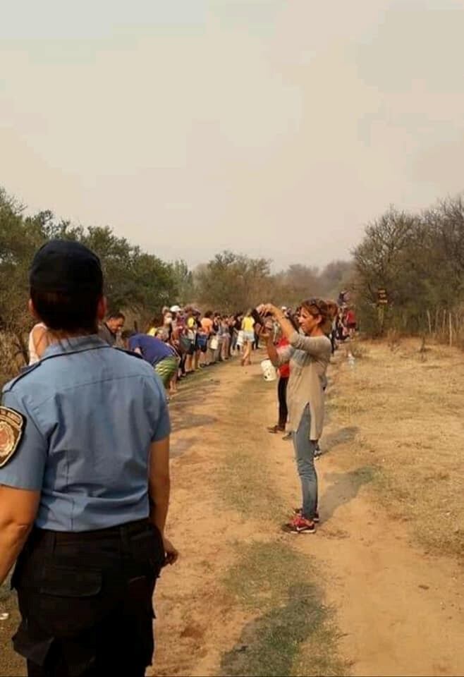 En Mina Clavero se formó un corredor humano de acarreo de agua para combatir los incendios. (Belen Intima)