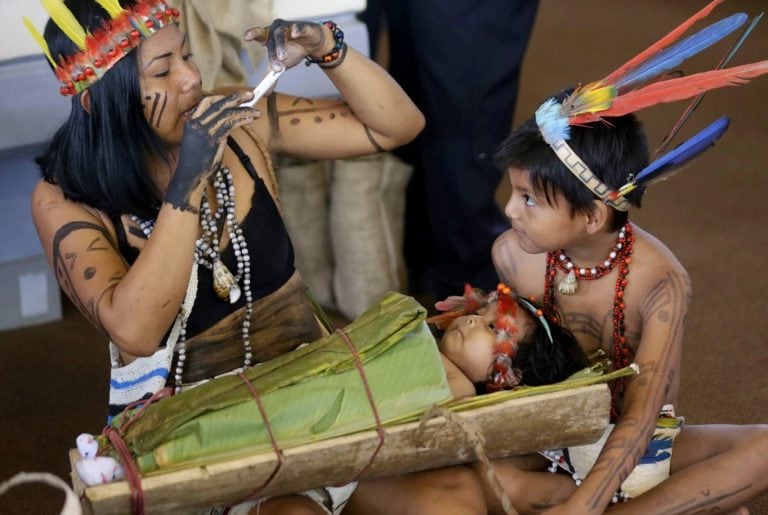 Una mujer indígena le toma una fotografía a dos niños mientras esperan la llegada del papa Francisco a Puerto Maldonado, Perú, el 19/01/2018. En Puerto Maldonado el papa se reunirá con pueblos indígenas de la Amazonía y niños y adolescentes de un albergue. La ciudad amazónica, de casi 100.000 habitantes, concentra los principales problemas que amenazan al Perú: pobreza, abandono, discriminación, contaminación y actos ilícitos como la tala de madera y la minería ilegal, explotación laboral. (Vinculado a la cobertura del día de dpa) Foto: Carlos Lezama/Agentur Andina/dpa +++ dpa-fotografia +++