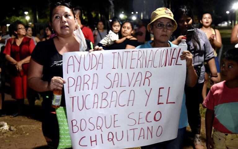 Jóvenes protestan exigiendo al Gobierno boliviano que declare un desastre natural debido a los incendios forestales en la región, fuera del edificio donde se reúne el gabinete ambiental boliviano en Robore, Santa Cruz, Bolivia, este domingo. (Photo by AIZAR RALDES / AFP)