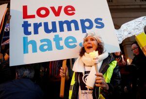 A woman holds a sign and a candle as she takes part in the women's rights event "Lights for Rights", a protest against the inauguration of Donald Trump as new U.S. president, in front of the Theatre Royal de la Monnaie in Brussels, Belgium, January 20, 2017. REUTERS/Francois Lenoir