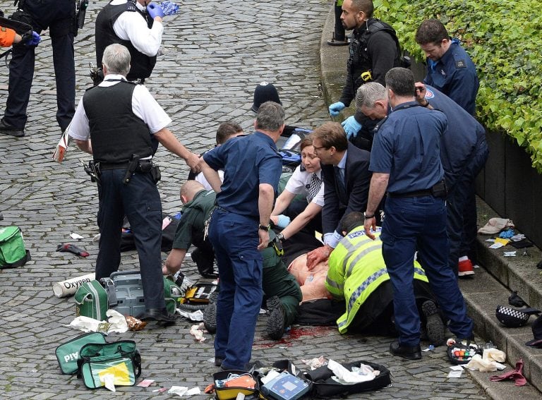 Conservative Member of Parliament Tobias Ellwood, centre, helps emergency services attend to an injured person outside the Houses of Parliament, London, Wednesday, March 22, 2017. London police say they are treating a gun and knife incident at Britain's P