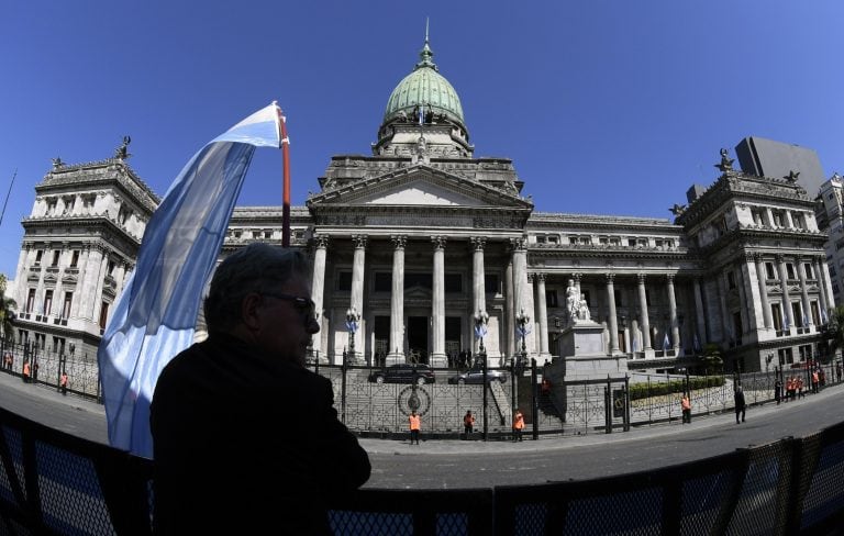 A supporter stands outside the Congress while Argentine President Mauricio Macri (not in frame) delivers the inauguration speech for the 136th period of ordinary sessions at the Congress in Buenos Aires, Argentina on March 1, 2018. / AFP PHOTO / JUAN MABROMATA