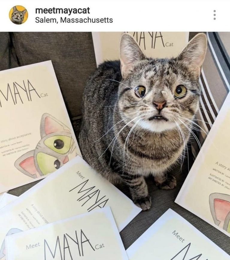 Maya junto al libro publicado por su dueña.