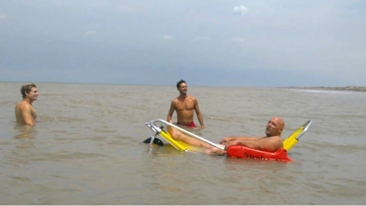 Gustavo D'angelo utilizando la silla que diseño junto a su padre  y que cada vez está en más playas argentinas y de sudamérica