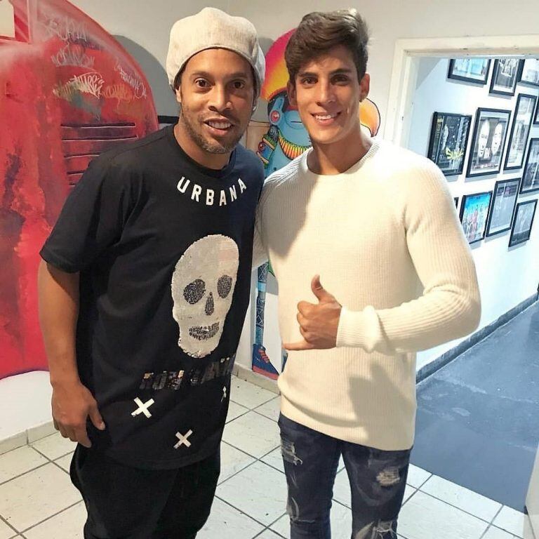 Thiago Ramos posando junto a Ronaldinho.