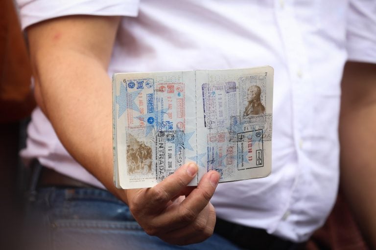 Un miembro del equipo del jefe del Parlamento venezolano, Juan Guaidó, muestra el pasaporte del líder opositor durante su discurso ante seguidores  (Foto: EFE/ Rayner Peña).