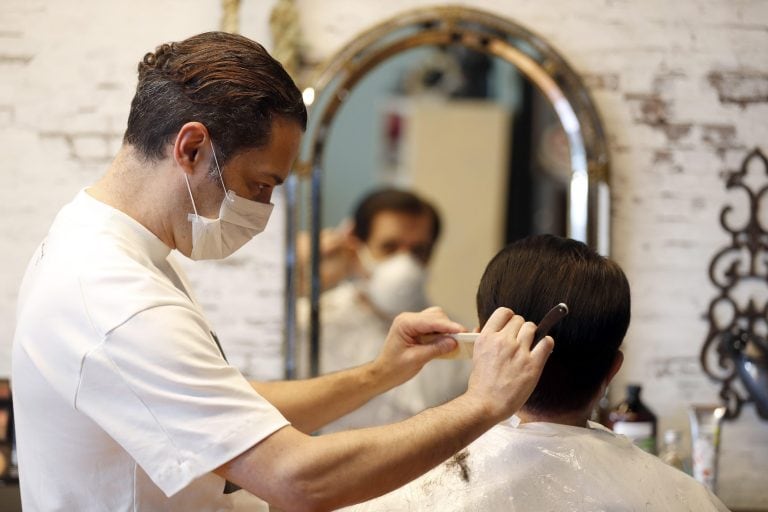 Un peluquero atiende a un cliente en Bilbao, España. (EFE)