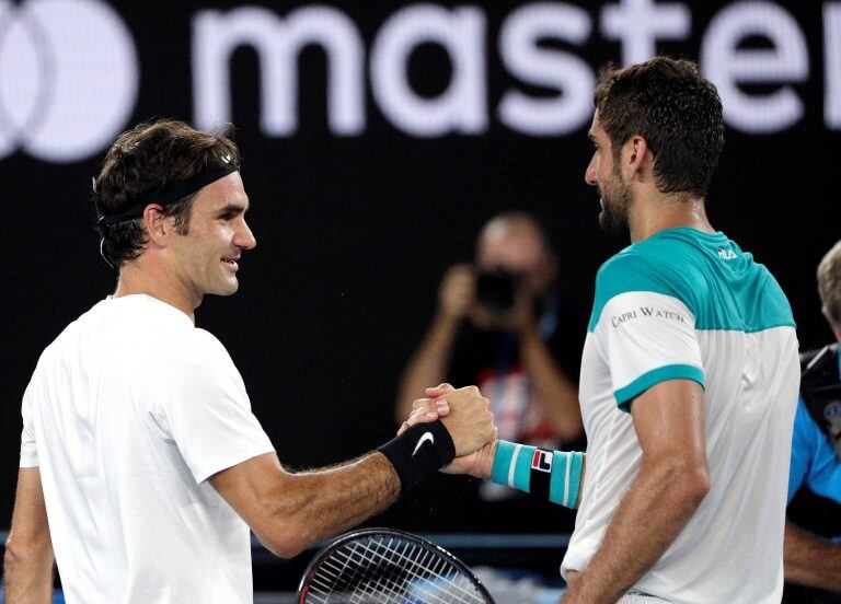 Switzerland's Roger Federer, left, is congratulated by Croatia's Marin Cilic after he won the men's singles final at the Australian Open tennis championships in Melbourne, Australia, Sunday, Jan. 28, 2018. (AP Photo/Dita Alangkara)