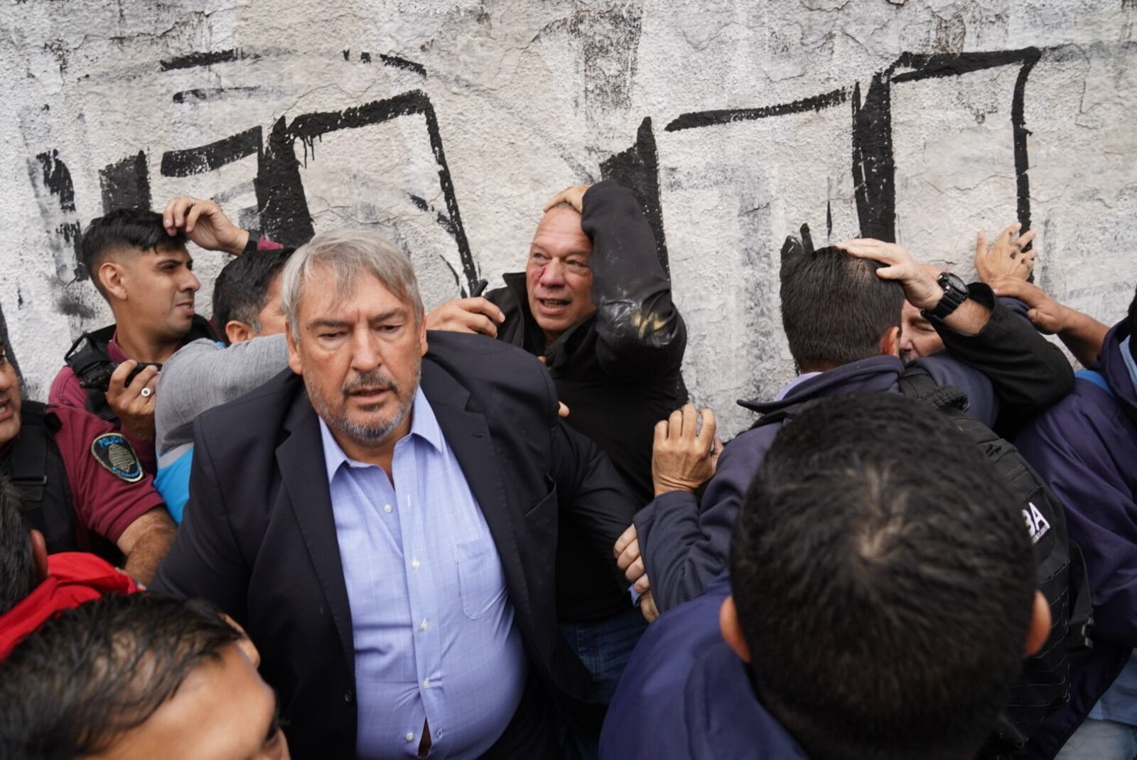 Así evacuaban a Sergio Berni tras el ataque a golpes en la protesta por el crimen del colectivero (Foto: Maxi Failla / Clarín)