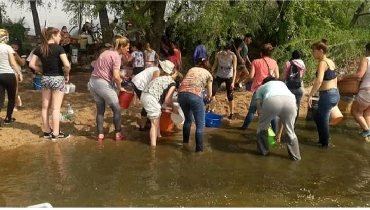 En Mina Clavero se formó un corredor humano de acarreo de agua para combatir los incendios. (Belen Intima)