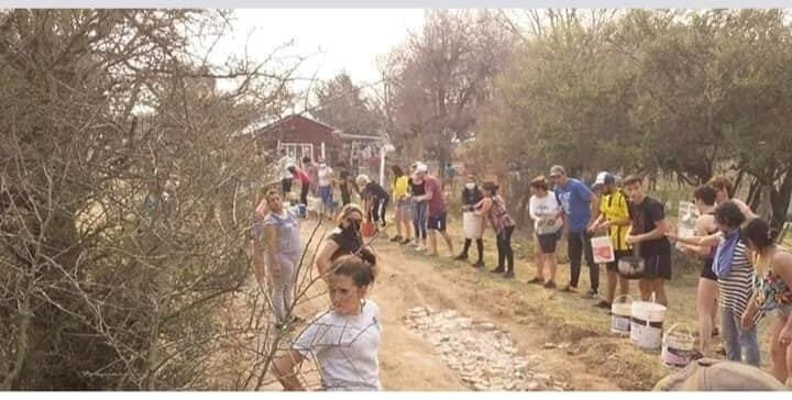 En Mina Clavero se formó un corredor humano de acarreo de agua para combatir los incendios. (Belen Intima)