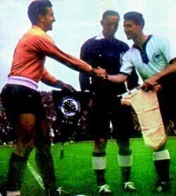 El capitán Pedro Dellacha, de la Selección argentina, intercambia banderines con el campeón alemán Fritz Walter. Los Albelestes, de amarillo. Inédito.