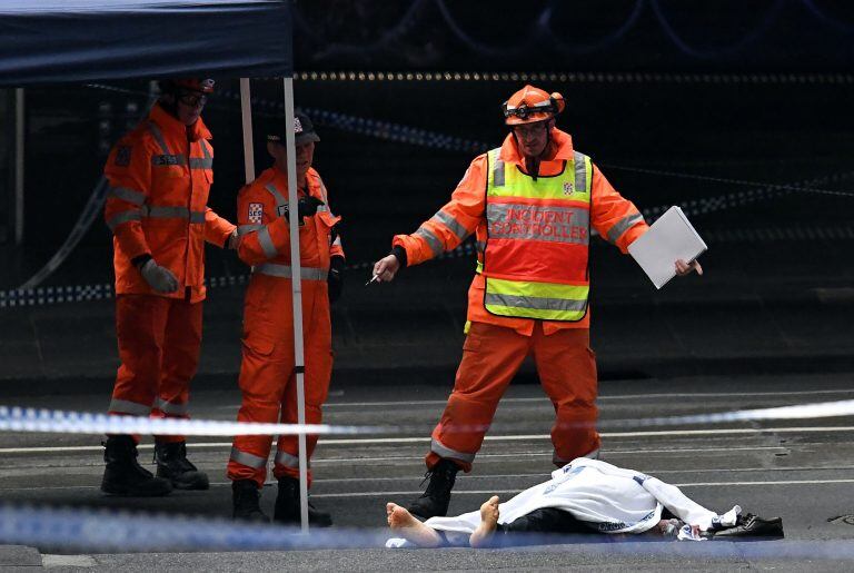 Personal del Servicio de Emergencia Estatal trabajan en la escena del crimen. Crédito:  WILLIAM WEST / AFP.