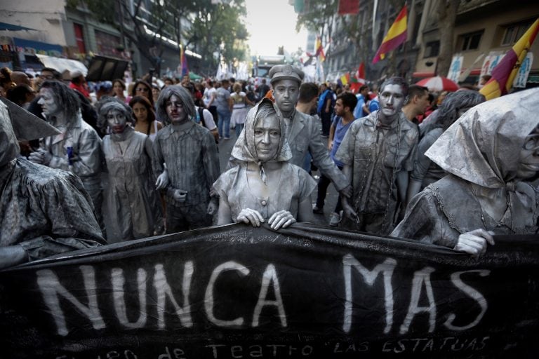 Actresses representing the mothers of Plaza de Mayo, front, hold a banner that reads in Spanish: "never again," during a march marking the 41th anniversary of the military coup in Buenos Aires, Argentina, on Friday, March 24, 2017. Tens of thousands of pe