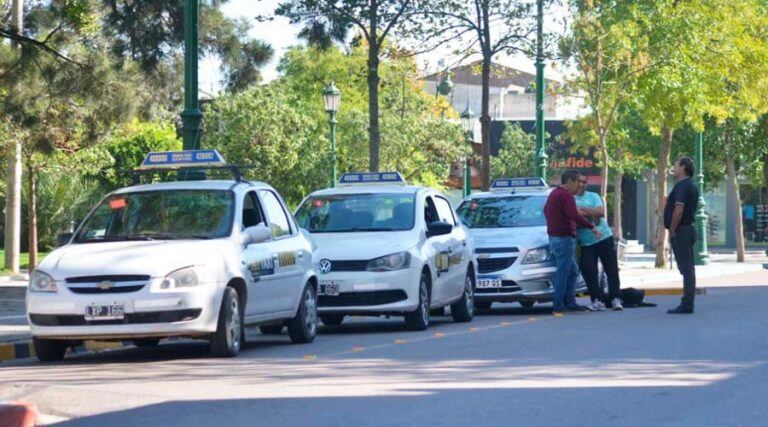 Los taxistas charlan entre ellos mientras esperan algún pasajero que no llega (Vía Santa Rosa)