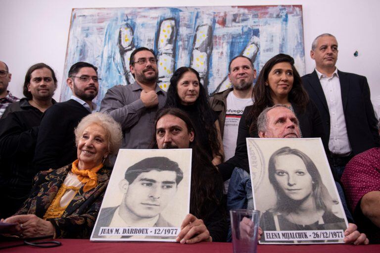 Javier Matias Darroux junto a su tío Roberto y Estela de Carlotto . Muestran los retratos de los padres desaparecidos de Javier. (Foto: EFE).