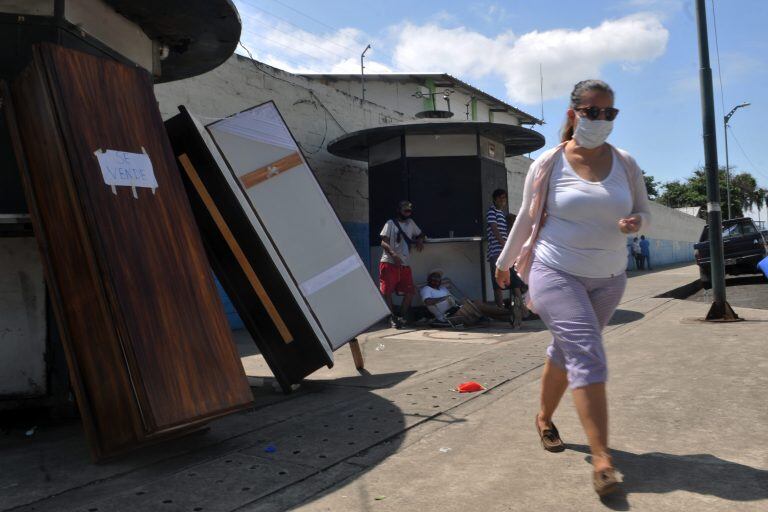 Ataúdes son exhibidos para la venta, fuera del hospital "Abel Gilbert Ponton" en Guayaquil, el 25 de abril de 2020. Ecuador es el país más afectado por el Covid-19 en América Latina después de Brasil. La Fiscalía de Ecuador ha abierto una investigación por la compra a sobreprecio para ese hospital de bolsas de cadáveres a 148 dólares, en lugar de los 12 que suelen costar en el mercado. Es la nueva vuelta de tuerca de la telenovela que salpica una y otra vez a la ciudad ecuatoriana más castigada por el Covid-19, Guayaquil, donde los escándalos se reproducen desde hace dos meses poniendo en tela de juicio la gestión gubernamental de la crisis. El nuevo caso de presunta corrupción, por el que hay cuatro personas bajo arresto preventivo, está relacionado, esta vez, con sobreprecios en la compra de insumos médicos en un hospital público, y entre ellos 4.000 bolsas para la recogida de cadáveres. (Photo by JOSE SANCHEZ LINDAO / AFP)