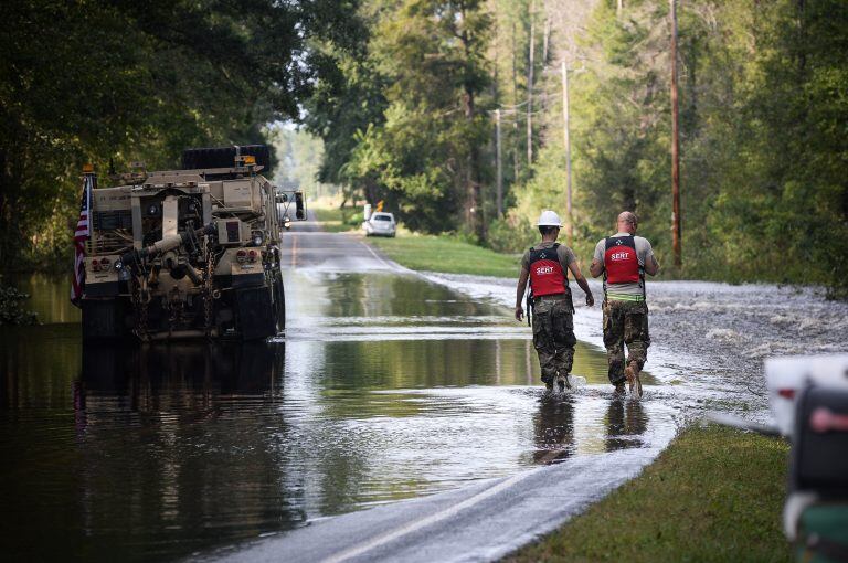 Miembros de la Guardia Nacional caminan por una ruta inundada tras el paso de Florence. Crédito: Charles Mostoller/Bloomberg