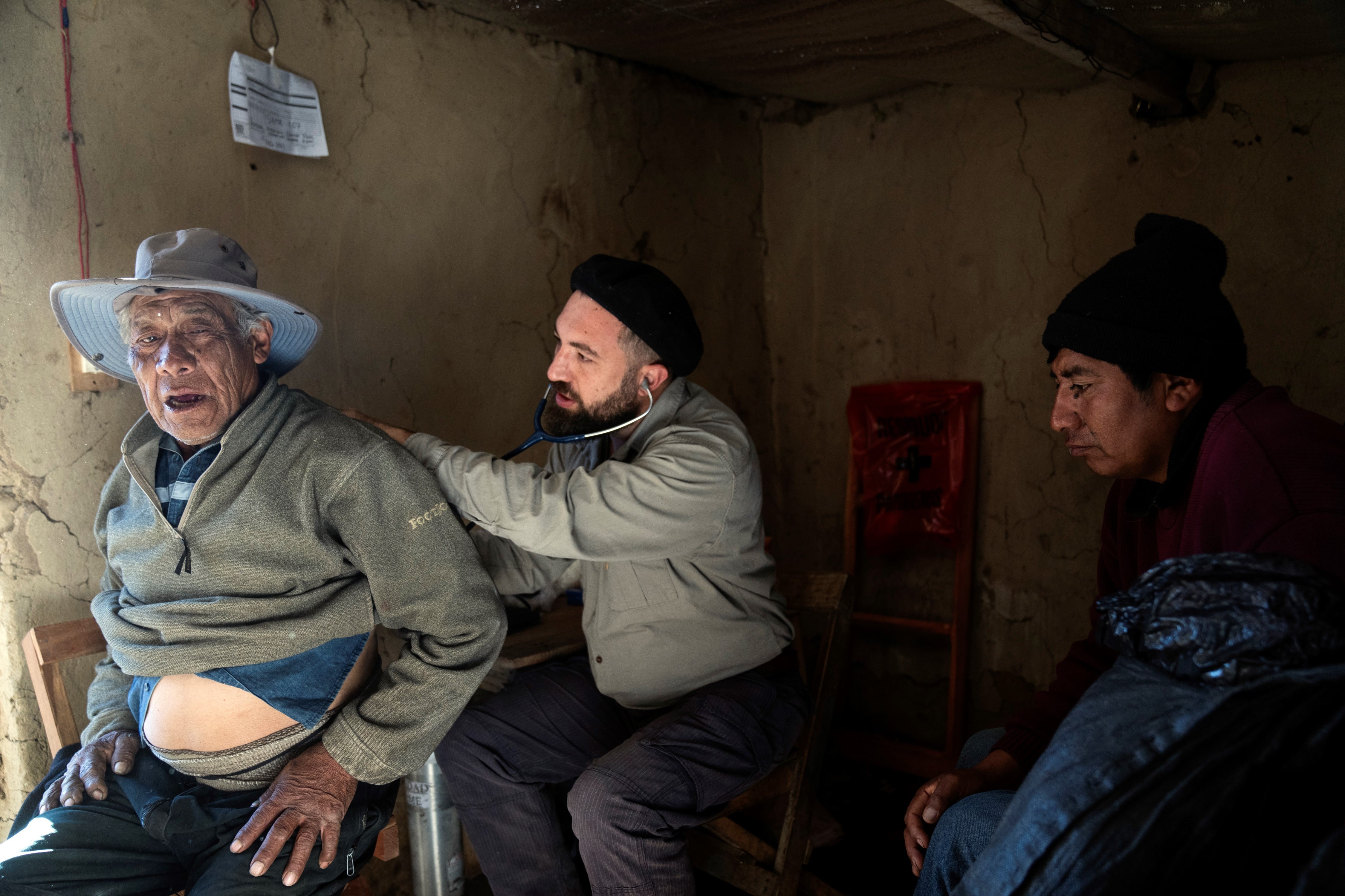 El Dr. Fusaro examina al paciente Damián Santos en una típica casa con paredes de adobe que sirve como consultorio médico temporario, durante su recorrida por las comunidades del sagrado Cerro Chañi.