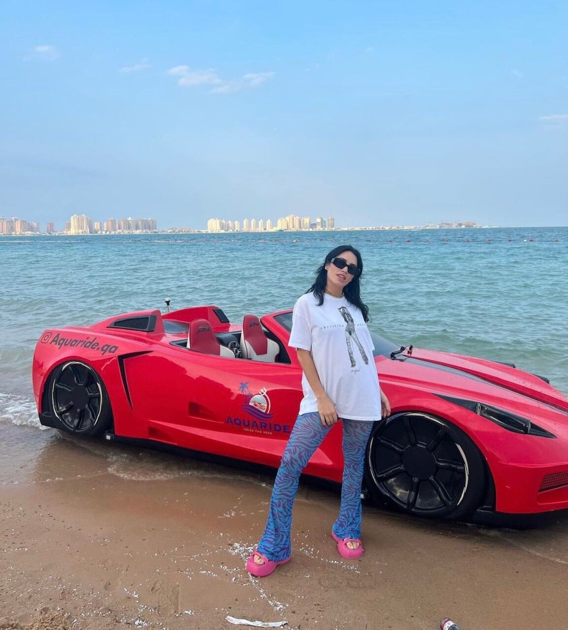 Lali lució sandalias rosas con plataforma en la playa de los Emiratos Árabes.